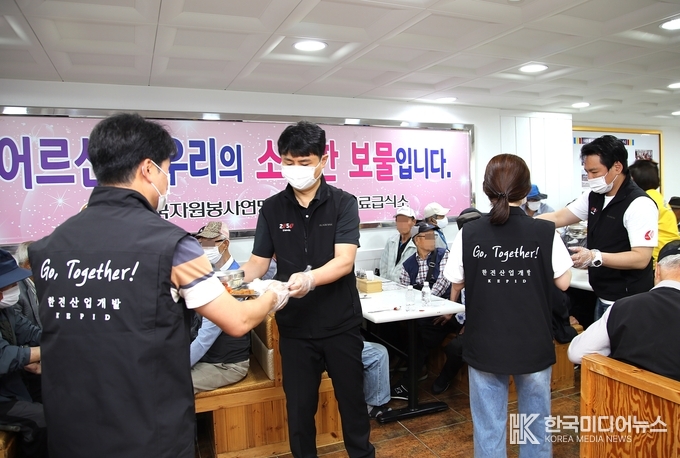 =사진설명 ; 11일(화) 무료급식 봉사활동에 참여한 한전산업개발 임직원들이 식사를 나르는 모습이다.