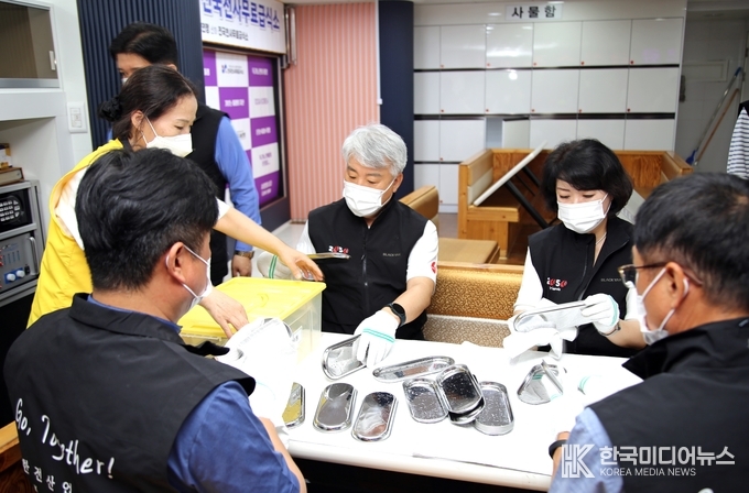 =사진설명 ; 함흥규 한전산업개발 대표(좌측)와 박신옥 대외협력처장(우측) 등이 무료급식 활동이 끝난 후 식기를 정리하고 있는 모습이다.