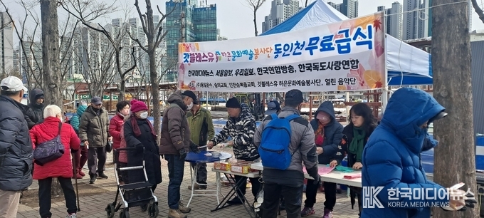 =사진설명 ; 동인천 복광장에서 이종목 목사외 송혜경 전도사가 봉사자와 무료급식을 하고있다.