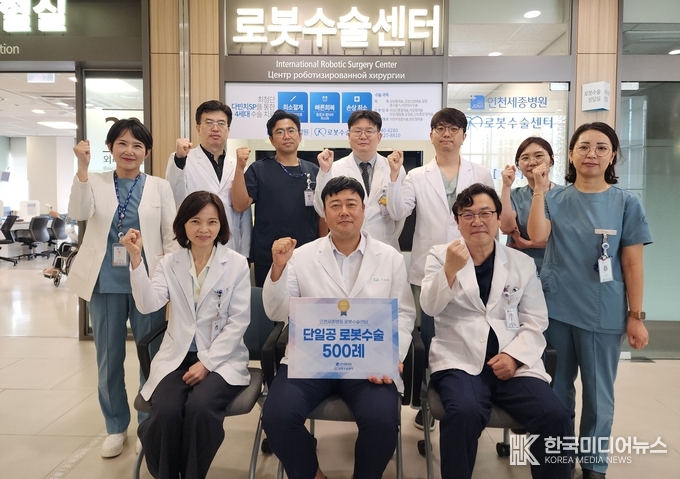 =<사진설명 : 지난 2일 인천세종병원 이성배 로봇수술센터장(외과·사진 아랫줄 가운데) 등 의료진이 병원 본관 로봇수술센터 앞에서 다빈치SP 단일공 로봇수술 500례 달성을 축하하며 기념 촬영하고 있다. / 인천세종병원 제공>