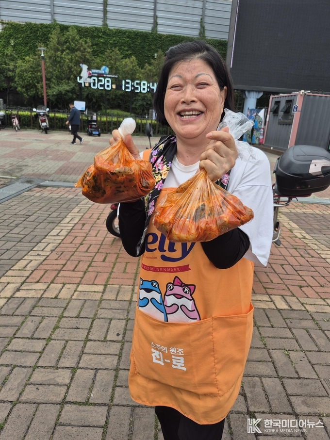  =사진설명 ; 조명탄 목사가 서은영대표가 기부한 갓 김치를 나누워 주고있다.