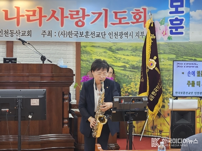 사진설명 ; 신금순 목사가 섹스폰 연주를 하고 있다.