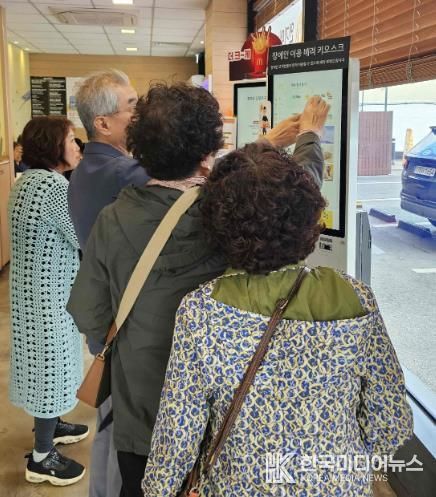 밀양시 삼문동 맥도날드 밀양DT점에서 열린 디지털 키오스크 문해교육 현장실습에 참여한 학습자들이 키오스크를 직접 조작하며 주문을 연습하고 있다.