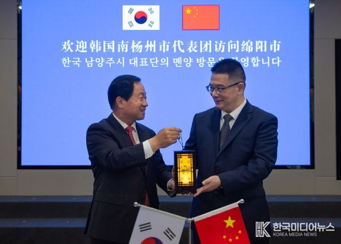 주광덕 남양주시장(좌)이 리원 몐양시장(우)에게 기념품을 전달하고 있다.