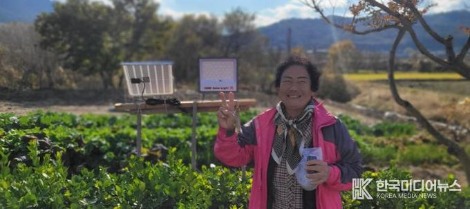 설치된 태양광 외등 앞에서 사진을 찍은 지원 가구