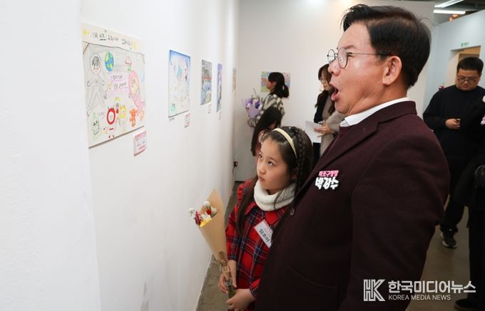 박강수 마포구청장이 수상 어린이와 함께 전시된 그림을 살펴보고 있다.