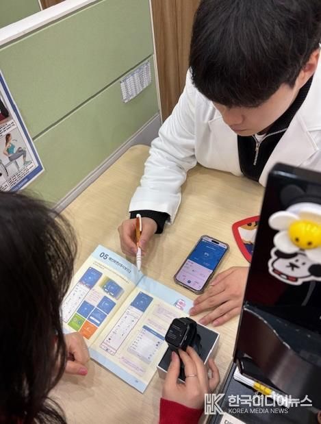 모바일 헬스케어사업 참여자가 모바일 앱(채움건강)과 활동량계(스마트밴드)에 대한 설명을 듣고 있다.