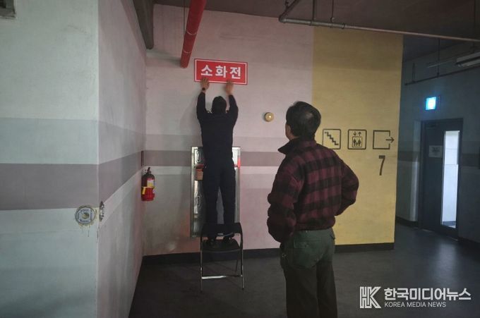 영동소방서 관계자가 아파트 지하주차장에 '보이는 소화전' 표지를 부착하고 있는 모습