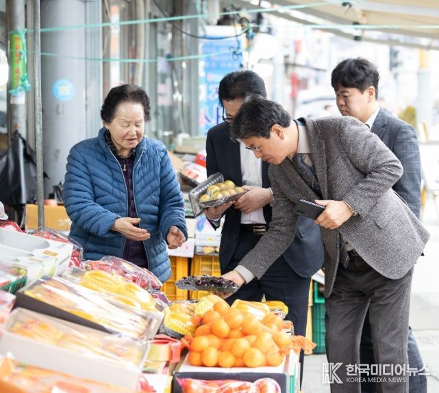 지난달 27일 김돈곤 청양군수가 농어촌 기본소득 지급 첫날 청양 전통시장을 방문해 물품을 구매하며 상인들의 애로사항을 청취하고 있다.