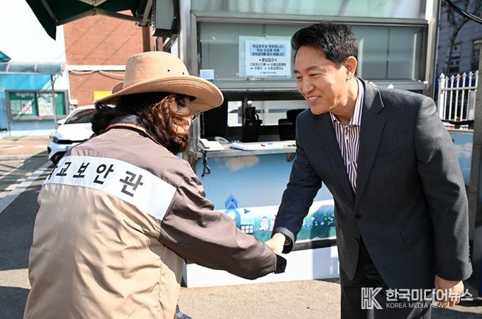 오세훈 서울시장이 13일 서울 소재 초등학교에서 학교보안관과 인사를 나누고 있다.
